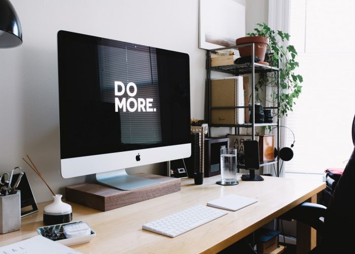 silver iMac with keyboard and trackpad inside room